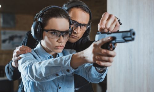 instructor helping customer in shooting gallery instructor helping customer in shooting gallery